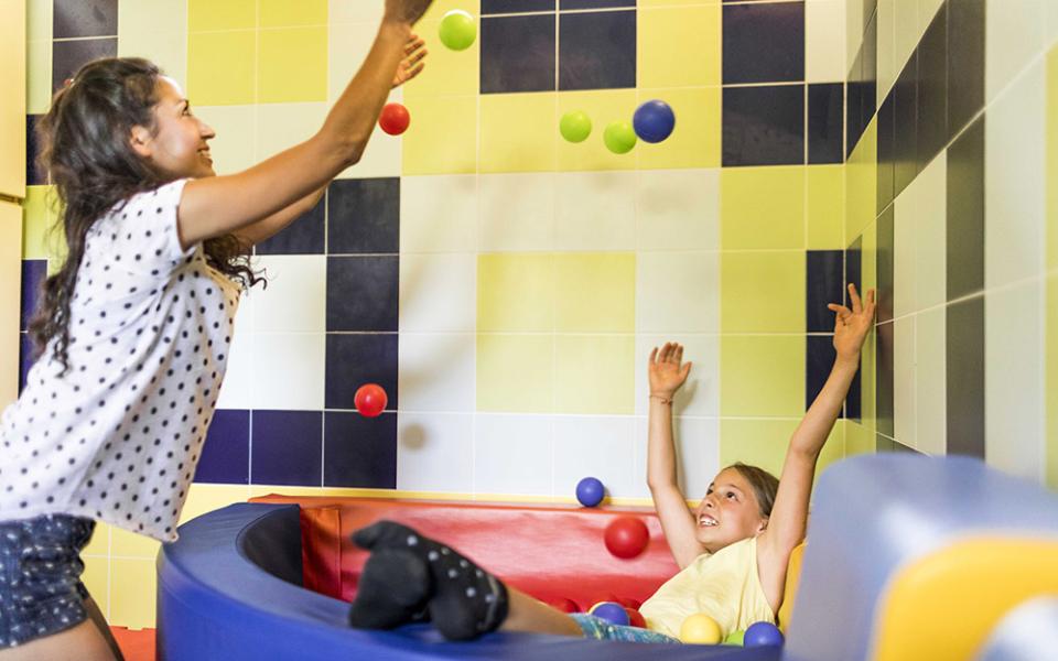 Due persone giocano in una piscina di palline colorate.