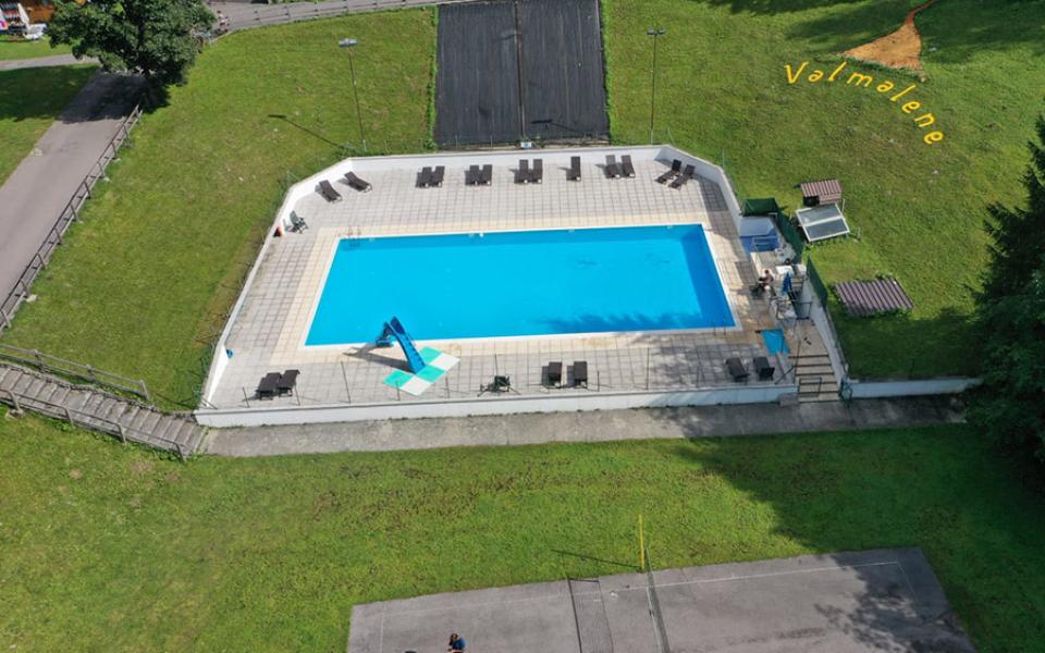 Piscina all'aperto con lettini, immersa nel verde di Valmalene.