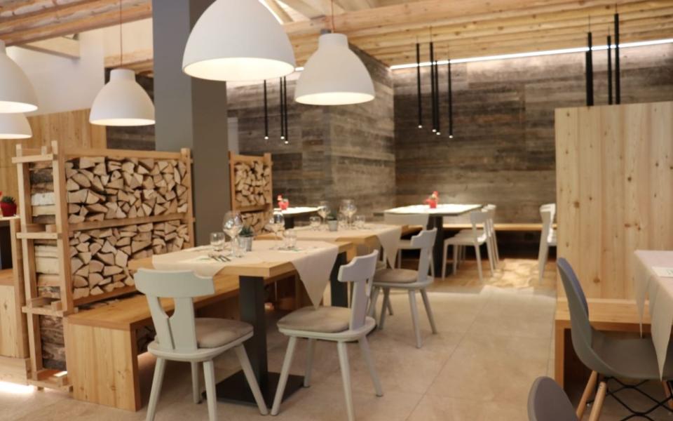 Ristorante moderno con arredi in legno e decorazioni naturali, atmosfera accogliente e luminosa.